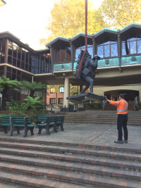 Lowering bronze sculpture using crane and slings to set bronze sculpture on site 